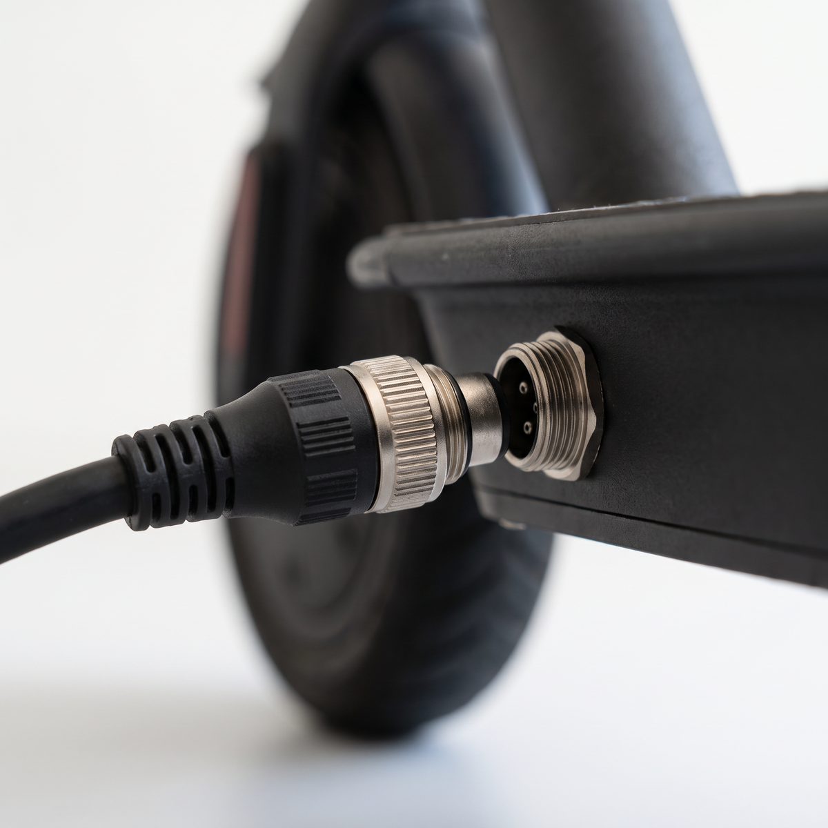VM 1 charger connector being plugged into the charge port on the scooter deck
