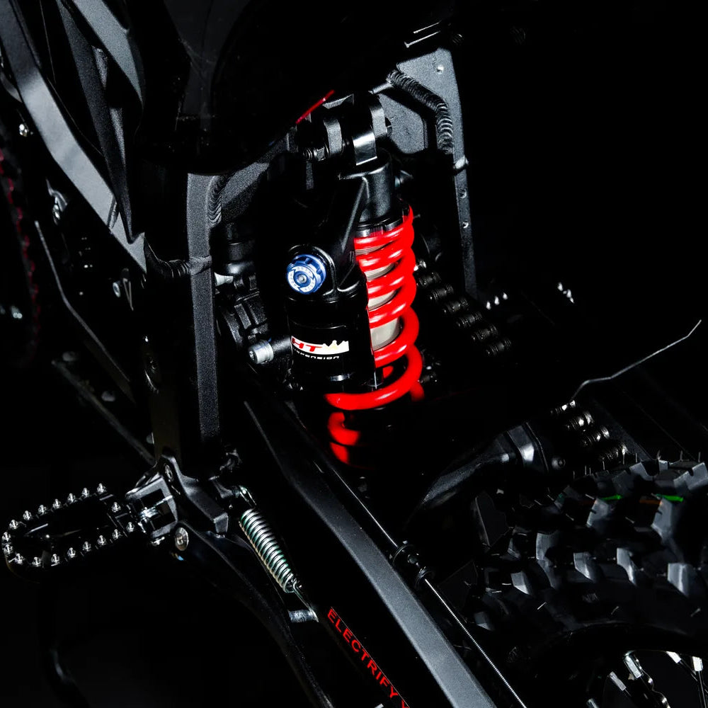 Red coil-spring rear shock on the Altis Sigma, with its blue adjuster knob
