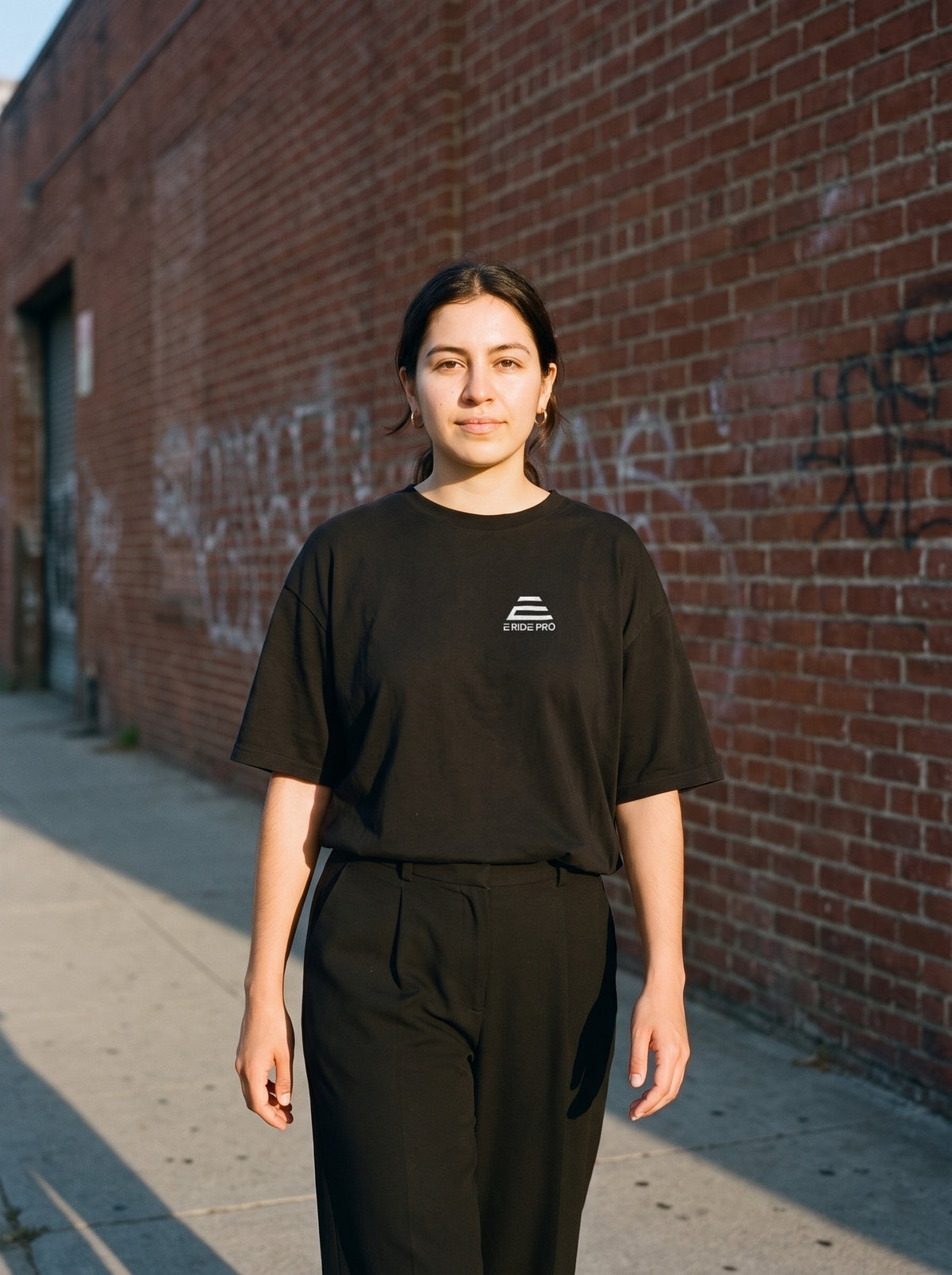 E Ride Pro Logo Tee in black worn by a woman, E Ride Pro logo printed on the left chest