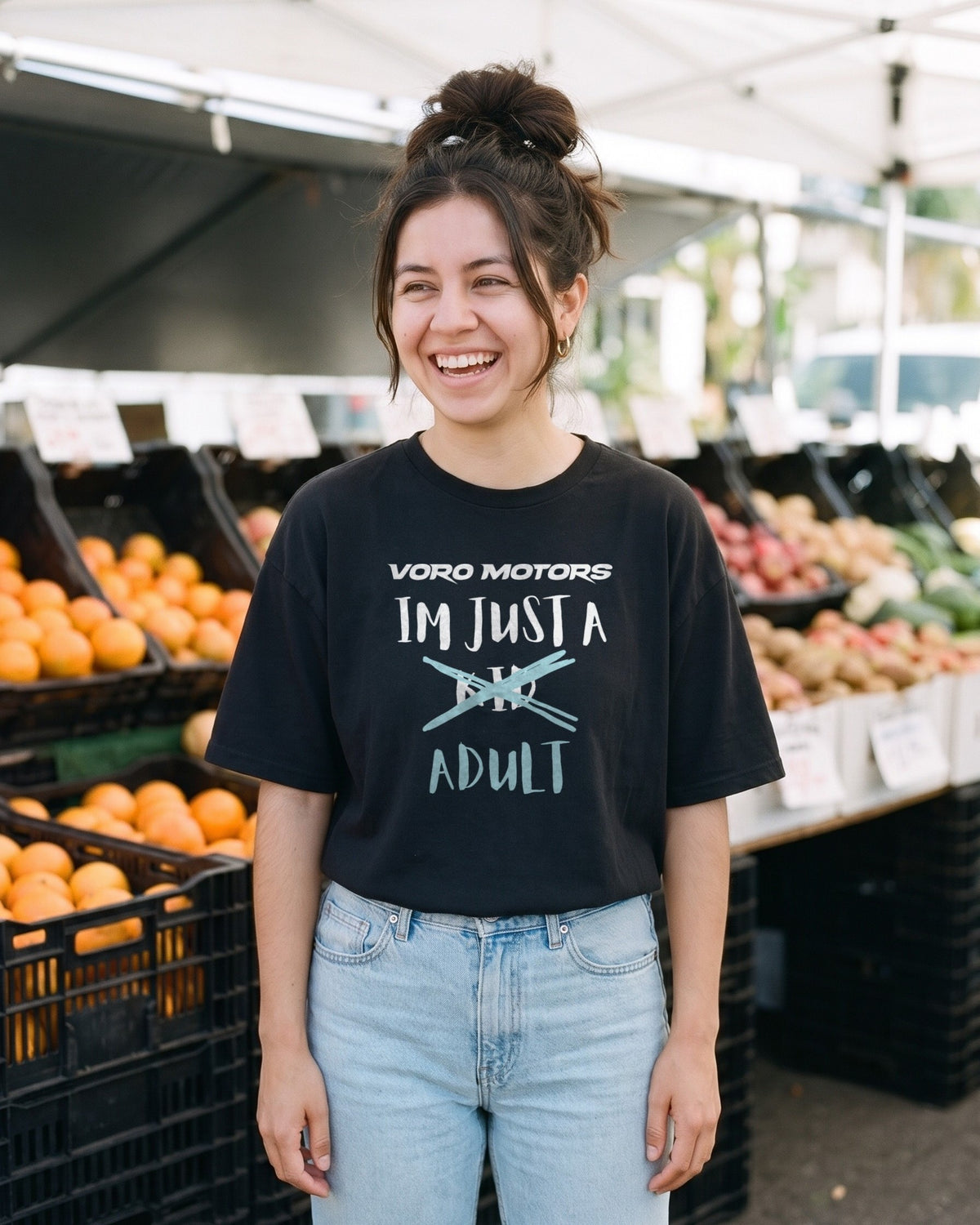 Woman laughing in the I'm Just a Kid Adult tee at the Silver Lake farmers market