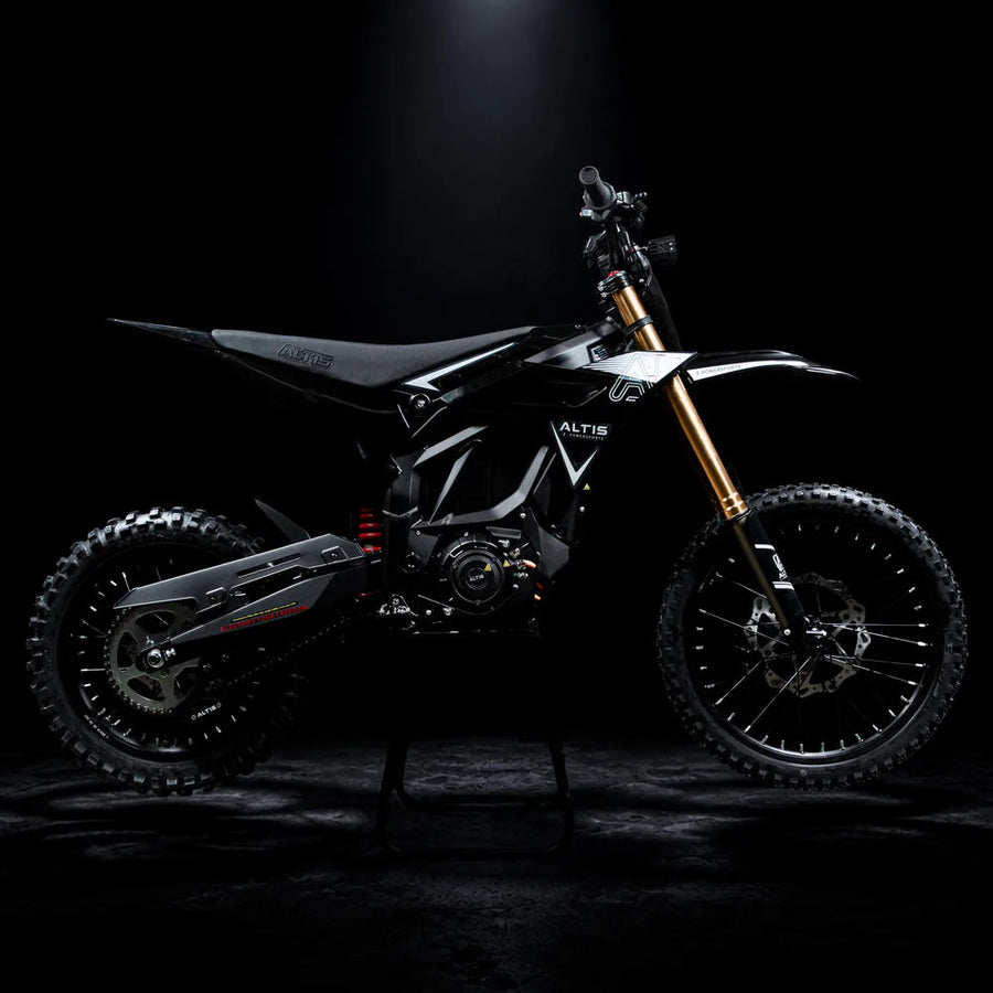 2027 Altis Sigma electric dirt bike in black, side profile facing right, with gold forks, on a stand in a dark studio