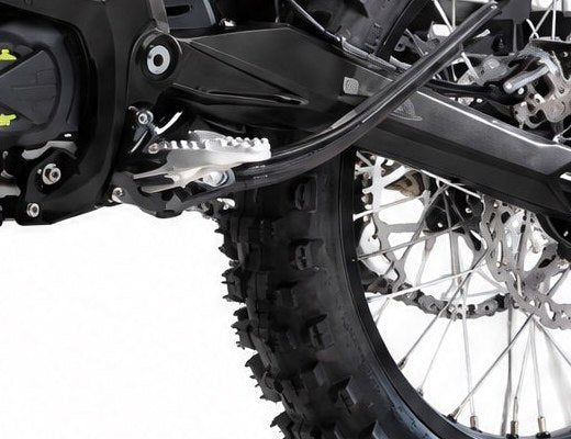 Foot peg fitted on the Surron Ultra Bee frame beside the rear wheel