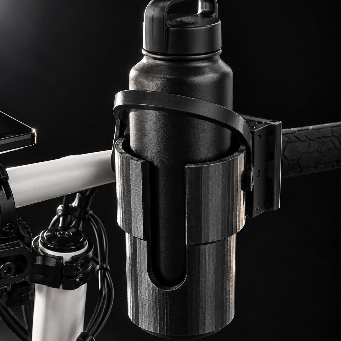 Holder with a water bottle clamped on the handlebar beside the grip
