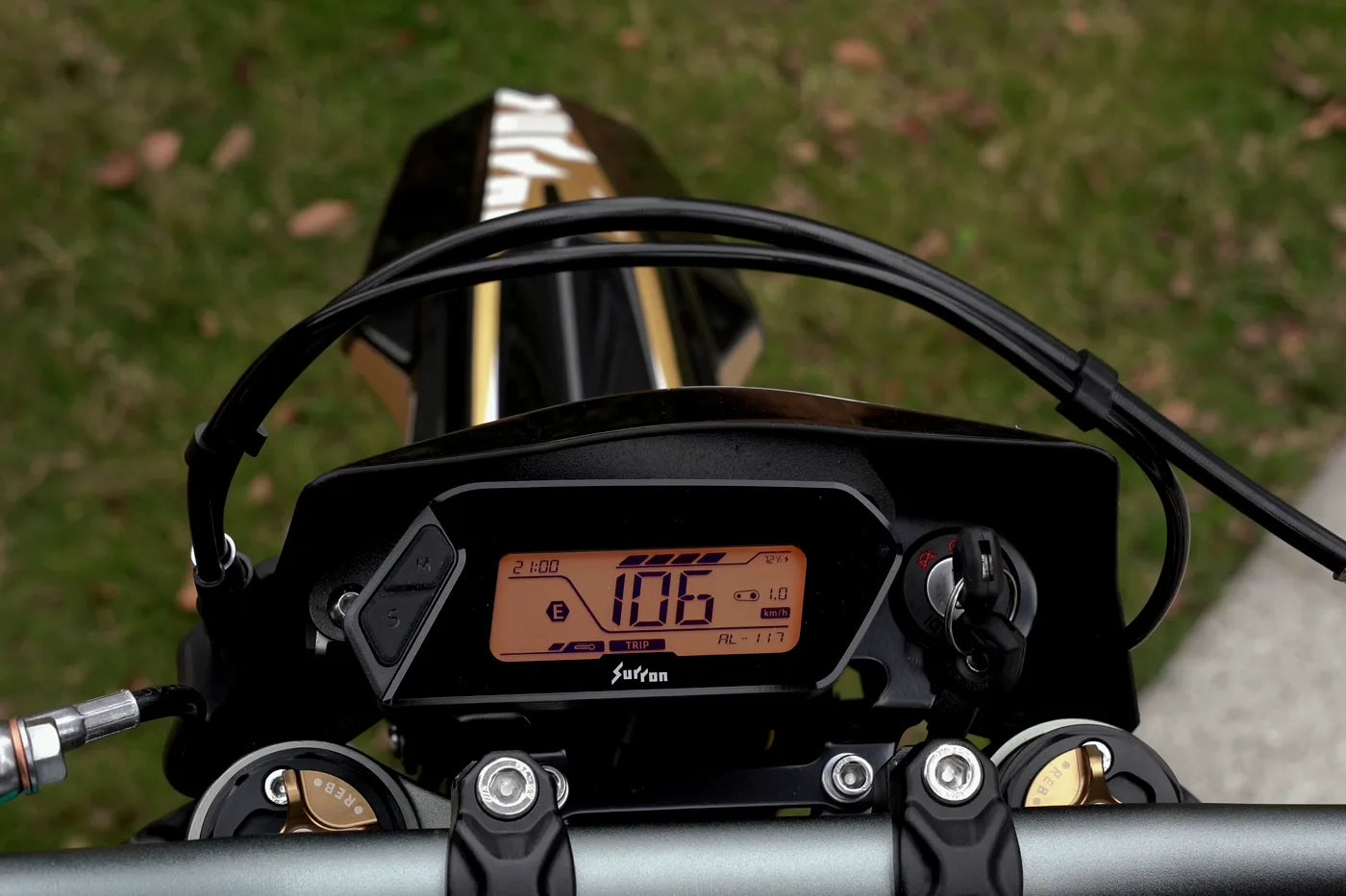 The Surron Ultra Bee cockpit: the backlit display in the centre and the button pod on the left bar